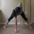 yoga prasarita padottanasna pose - a person in wide leg forward fold with a twist in the upper body
