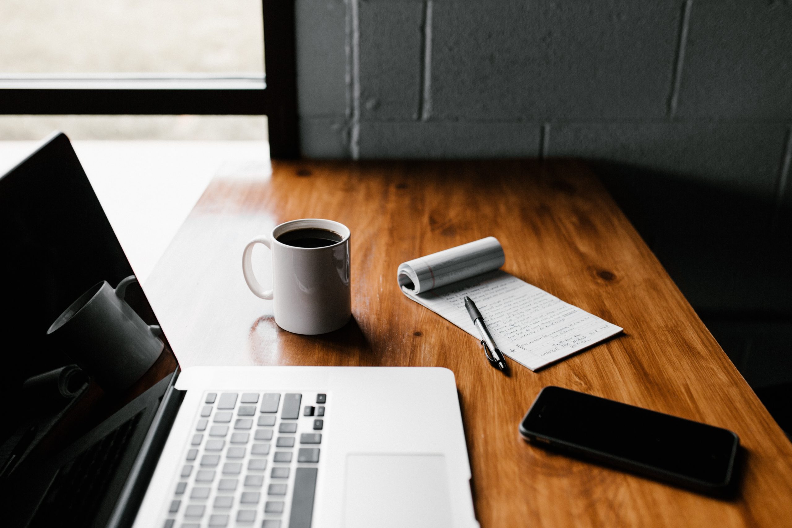 photo of computer, notepad and coffee mug