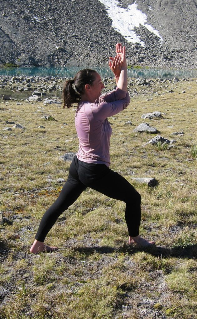 a person with arms in yoga eagle pose and legs in yoga Warrior I pose