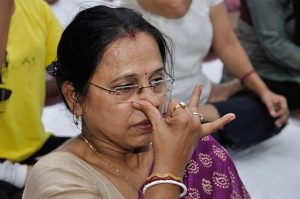 a woman with her fingers on her nose doing alternate nostril breathing