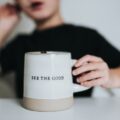 photo of a person holding a mug that has the words 'see the good' printed on it