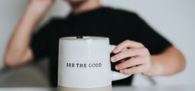 photo of a person holding a mug that has the words 'see the good' printed on it